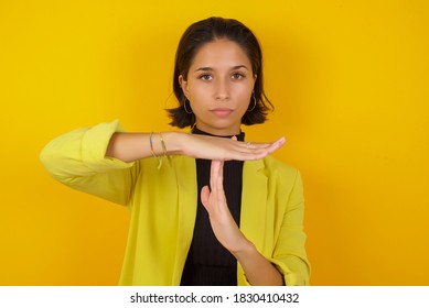 Young businesswoman wearing casual turtleneck sweater and jacket being upset showing a timeout gesture, needs stop, asks time for rest after hard work, demonstrates break hand sign - Powered by Shutterstock