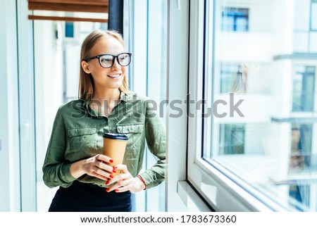 Young businesswoman while drinking coffee in the office