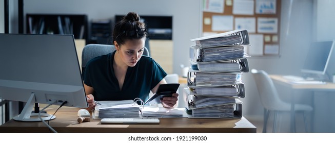 Young Businesswoman Working At Office With Stack Of Folders On Desk - Shutterstock ID 1921199030