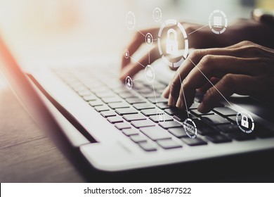 Young businesswoman working on his laptop in the office, select the icon security on the virtual display. Vintage tone concept