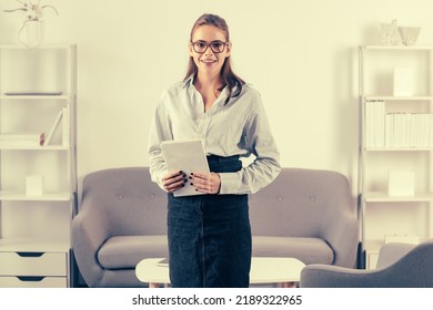 Young Businesswoman Working On Laptop With Too Much Work In Office. Secretary Girl Holding Note Book Or Notepad.