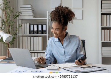 Young businesswoman works hard in her office, focused on finances and using modern technology - Powered by Shutterstock