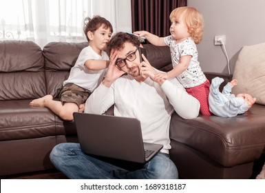Young busy father trying to work at home with his children. Self isolation. Stay home concept. Freelancer.