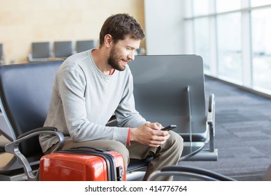 Young Busy Man Waiting For Departure At The Airport While Using His Phone