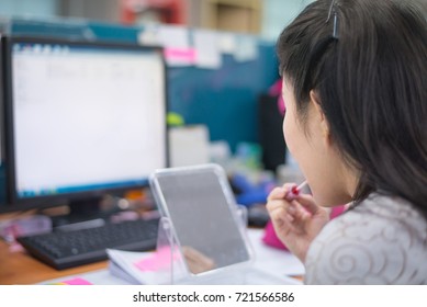 Young Busy Woman Make Up At Her Workplace In Office.Young Businesswoman Make Up In Work.