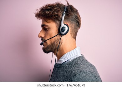 Young Call Center Agent Man With Beard Wearing Headset Over Isolated Pink Background Looking To Side, Relax Profile Pose With Natural Face With Confident Smile.