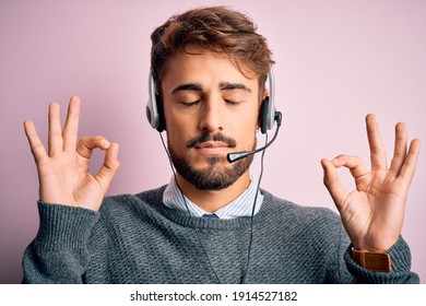 Young Call Center Agent Man With Beard Wearing Headset Over Isolated Pink Background Relax And Smiling With Eyes Closed Doing Meditation Gesture With Fingers. Yoga Concept.