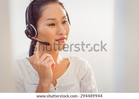 Young call centre representative using headset in office