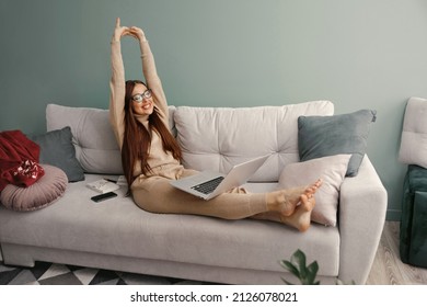 Young calm woman with laptop relaxing sit on comfortable sofa in at home after work, lazy happy  woman girl resting on couch enjoy peace of mind no stress free on couch.  Workplace at hom