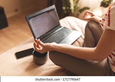 Young Calm Woman Sits In Staff Easy Lotus Pose Near Laptop At Home Interior, Meditating Alone On The Floor With Eyes Closed, Online Yoga Training, Doing Breathing Exercise In The Morning, No Stress