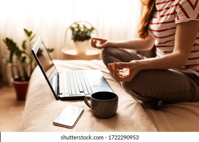 Young Calm Woman Sits In Staff Easy Lotus Pose Near Laptop At Home Interior, Meditating Alone On The Floor With Eyes Closed, Online Yoga Training, Doing Breathing Exercise In The Morning, No Stress