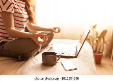 Young Calm Woman Sits In Staff Easy Lotus Pose Near Laptop At Home Interior, Meditating Alone On The Floor With Eyes Closed, Online Yoga Training, Doing Breathing Exercise In The Morning, No Stress