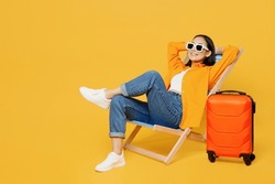 Young Calm Woman Wear Summer Clothes Sit In Deckchair Hold Hands Behind Neck Isolated On Plain Yellow Background. Tourist Travel Abroad In Free Spare Time Rest Getaway. Air Flight Trip Journey Concept