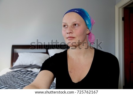Young cancer patient in headscarf looks into distance