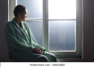 Young Cancer Patient Sitting In Front Of Hospital Window.