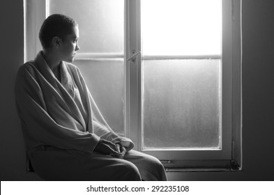 Young Cancer Patient Sitting In Front Of Hospital Window.