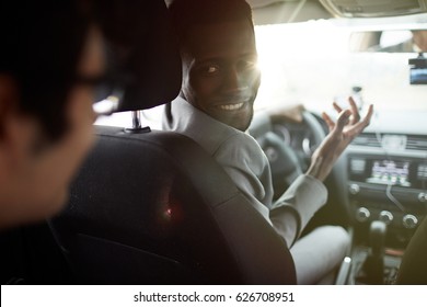 Young car driver asking businessman where to go