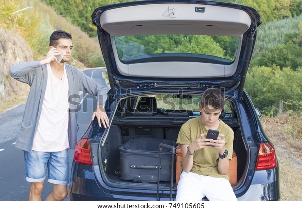 young with the car packed with suitcases and\
mobile phones