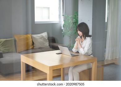 A Young Career Woman Telecommuting To An Online Meeting