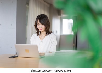 A Young Career Woman Telecommuting To An Online Meeting