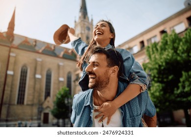 Young carefree couple piggybacking while traveling. - Powered by Shutterstock