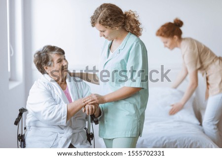 Similar – Caregiver helping elderly female patient to get out of bed