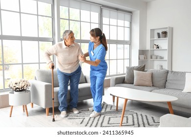 Young caregiver helping senior woman to walk at home - Powered by Shutterstock