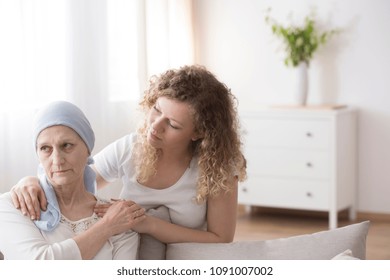 Young Caregiver Offering Support To An Older Woman In Headscarf, A Sick Cancer Patient