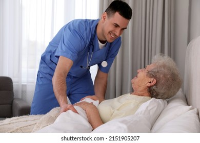 Young Caregiver And Senior Woman In Bedroom. Home Health Care Service