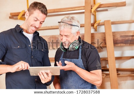 Similar – Image, Stock Photo Master carpenter and apprentice using a clamp for wood gluing in a workshop