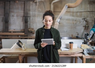 Young carpenter using digital tablet near safety visor and coffee to go in workshop - Powered by Shutterstock