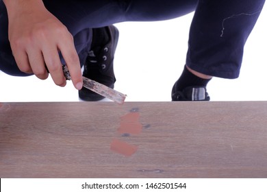Young carpenter in work clothes  using scraper and wood filler in finishing work  for sofa server project isolated on white background - Shutterstock ID 1462501544
