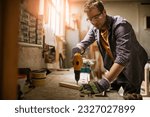 Young carpenter working in his woodworking workshop