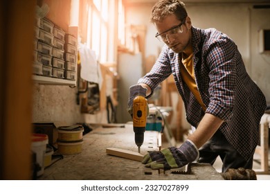 Young carpenter working in his woodworking workshop