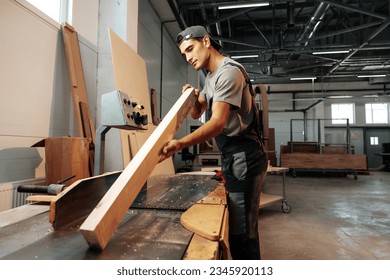 Young carpenter working on woodworking machines in the furniture factory - Powered by Shutterstock