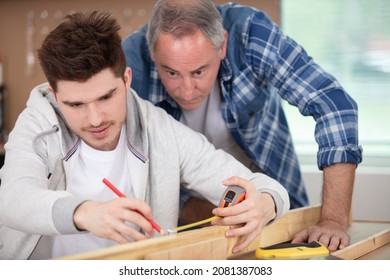 Young Carpentry Apprentice Measuring Plywood Tutor Watching