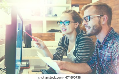 Young Casual Business Couple Using Computer In The Office. Two Colleagues Working Together On An Innovative Product Design In A Creative Studio. Coworking, Creative Manager Showing New Startup Idea