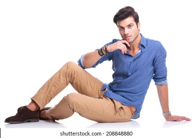 Young Casual Man Looking Pensive While Lying Down On White Background