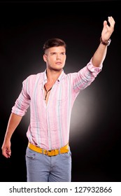 Young Casual Man Reaching And Looking Upwards, On Black Background