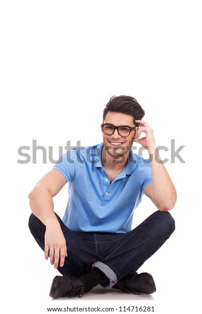 足を組んで頭を抱え カメラに微笑みながら座る若いカジュアルな男性 白い背景に の写真素材 今すぐ編集