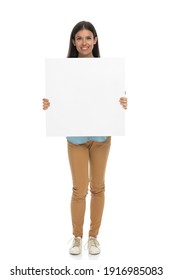 young casual woman showing a blank billboard at the camera against white background