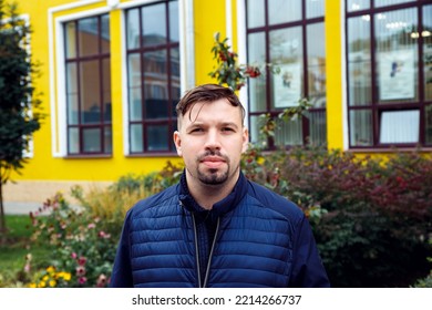 Young Caucasian 34 Years Old Man In Blue Jacket With Goatee Beard On Yellow Building. Looking At Camera Concentrated Entrepreneur Man, Businessman. Waist Up Lifestyle Business Portrait, Success 