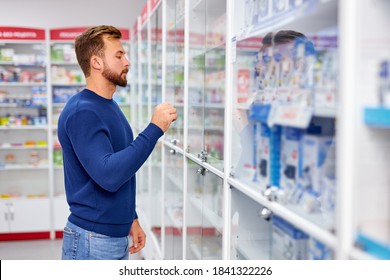 Young Caucasian Adult Man Is Suffering From Sore Throat, Need Some Medications In Pharmacy