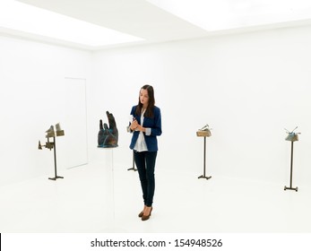 Young Caucasian Art Collector Looking At Contemporary Sculptures Displayed In A White Exhibition Space