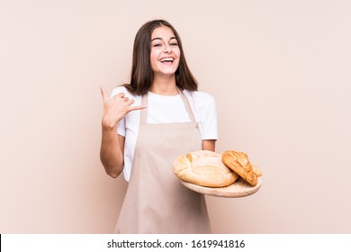 Young caucasian baker woman isolated showing a mobile phone call gesture with fingers. - Shutterstock ID 1619941816