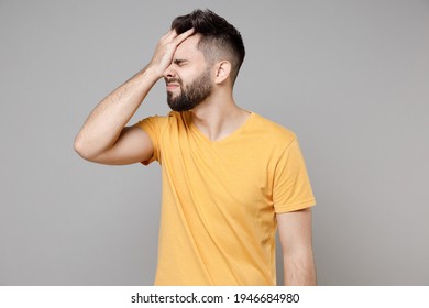 Young caucasian bearded mistaken man 20s wearing casual yellow basic t-shirt put hand on face facepalm epic fail gesture isolated on grey color background studio portrait. People lifestyle concept