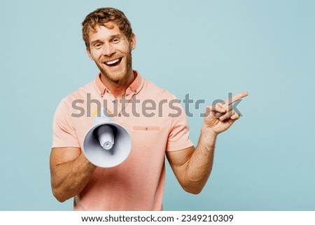 Young caucasian blond man he wears pink t-shirt casual clothes hold in hand megaphone scream announces discounts sale Hurry up point aside isolated on pastel plain light blue cyan background studio