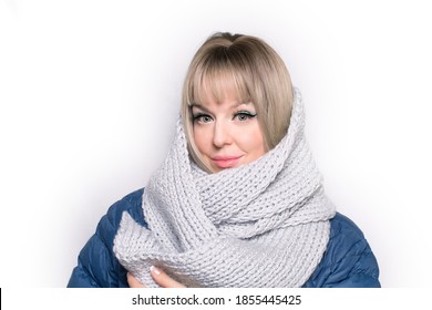 A Young Caucasian Blond Woman Looking Straight, No Mask, Holding Her Hands On The Scarf, Keeping Herself Warm, Isolated On The White Background