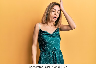 Young Caucasian Blonde Woman Wearing Elegant Party Dress Surprised With Hand On Head For Mistake, Remember Error. Forgot, Bad Memory Concept. 