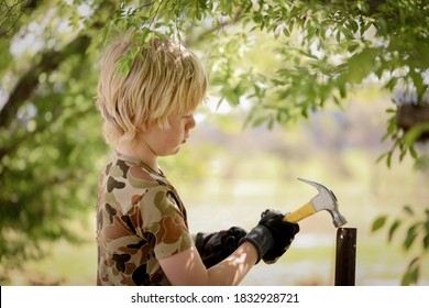 Young Caucasian Boy Building Treehouse In Lush Chinese Elm Tree